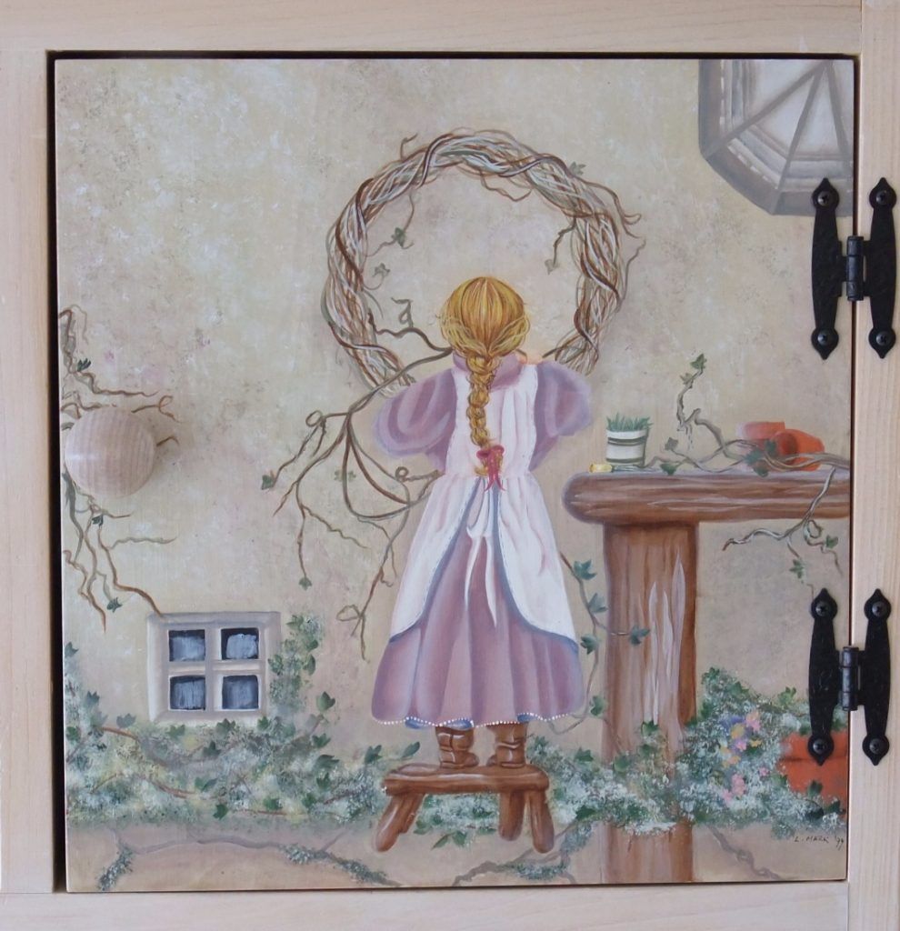 Folk art cabinet door hand-painted with a girl on a stool reaching for a twig wreath