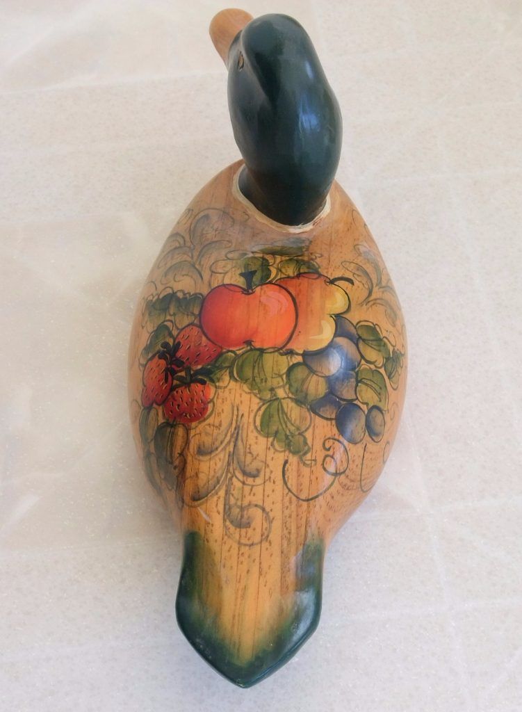 Folk art wooden duck decoy hand-painted with a fruit motif, seen from above