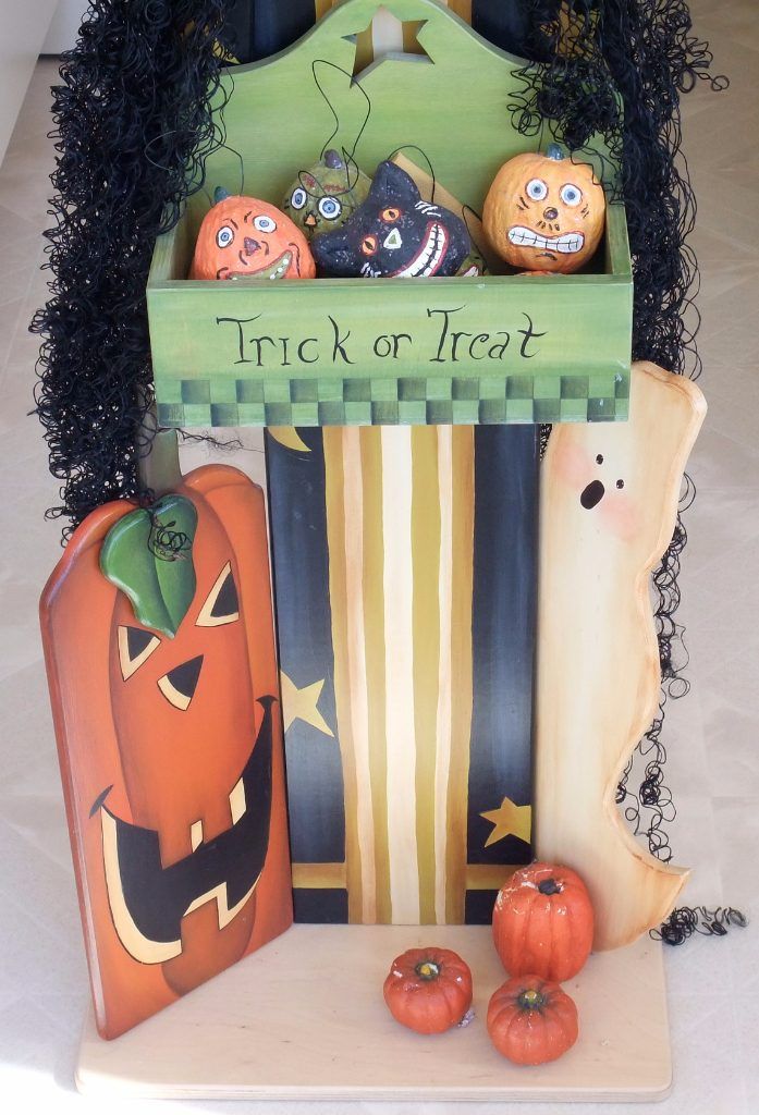 Detail of a folk art Halloween shelf with a Trick or Treat box, jack-o'-lantern, and ghost
