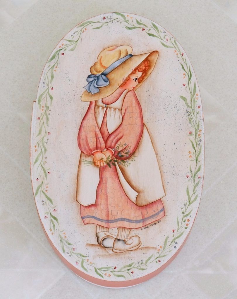 Oval folk art box hand-painted with a girl in a straw hat and pink dress