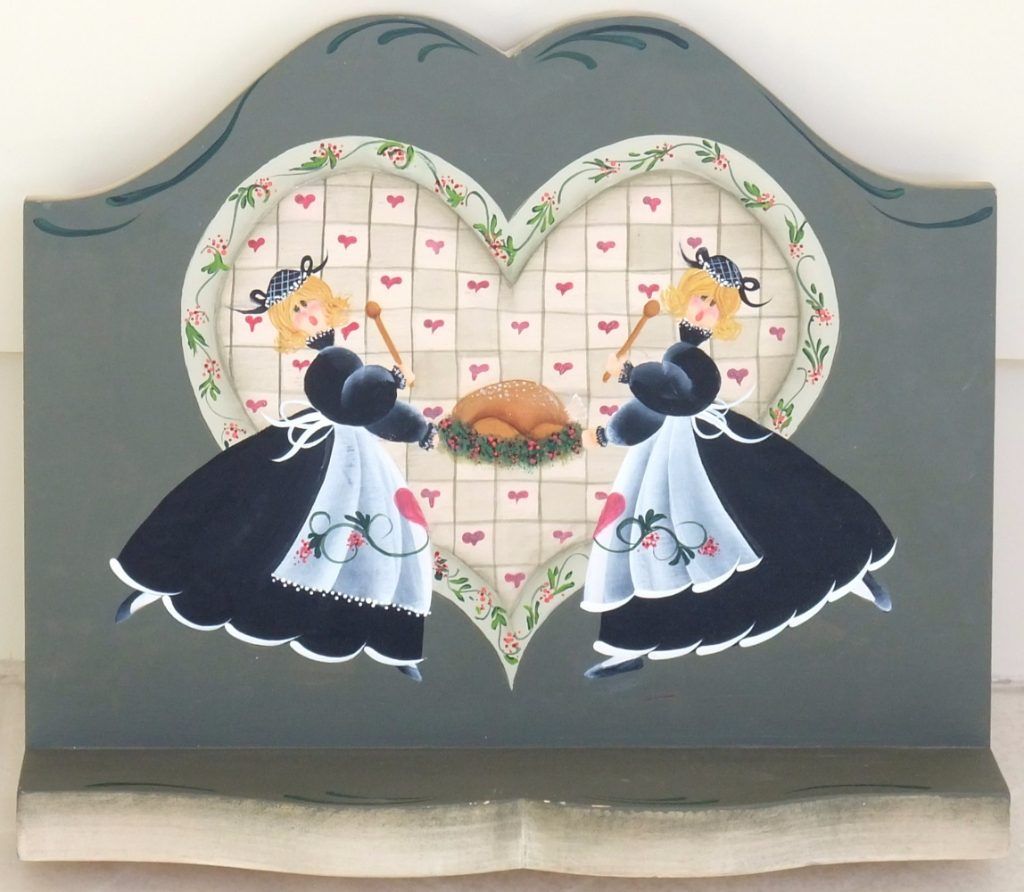 Grey folk art shelf hand-painted with two aproned cooks around a roast turkey