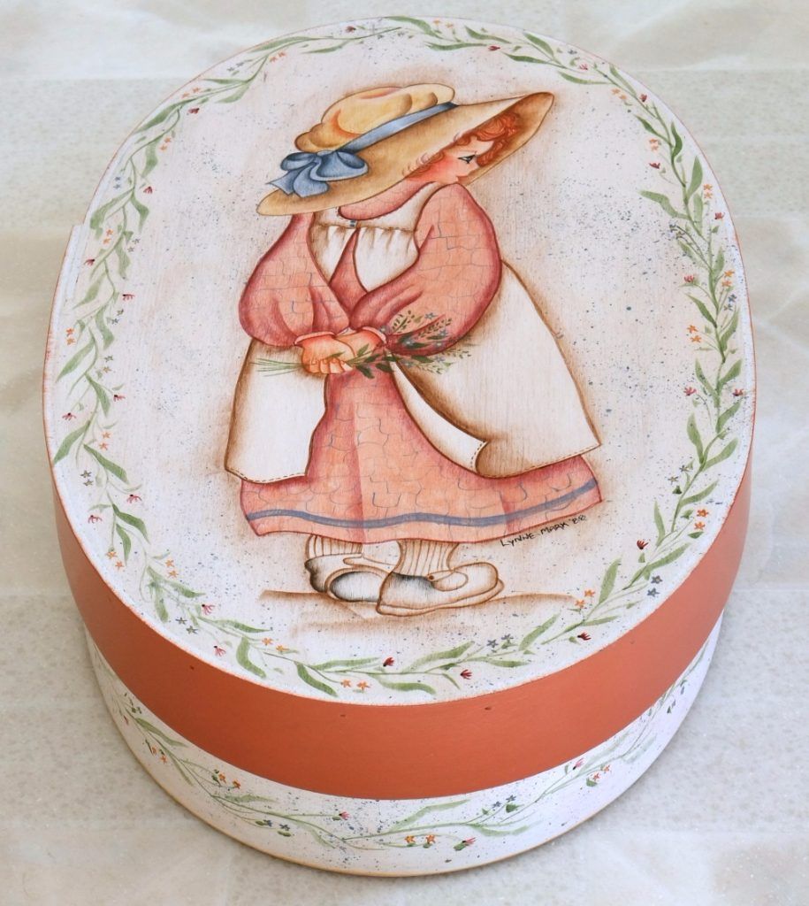 Oval folk art box hand-painted with a girl in a straw hat, shown from the side