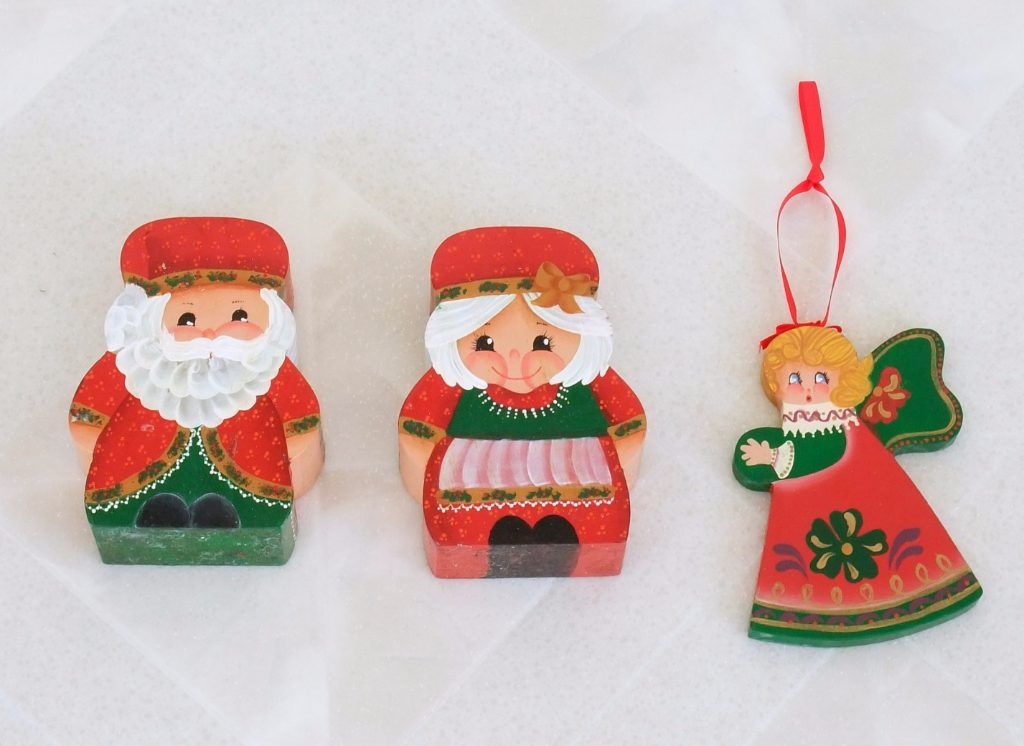 Folk art wooden figures of Santa, Mrs. Claus, and an angel ornament